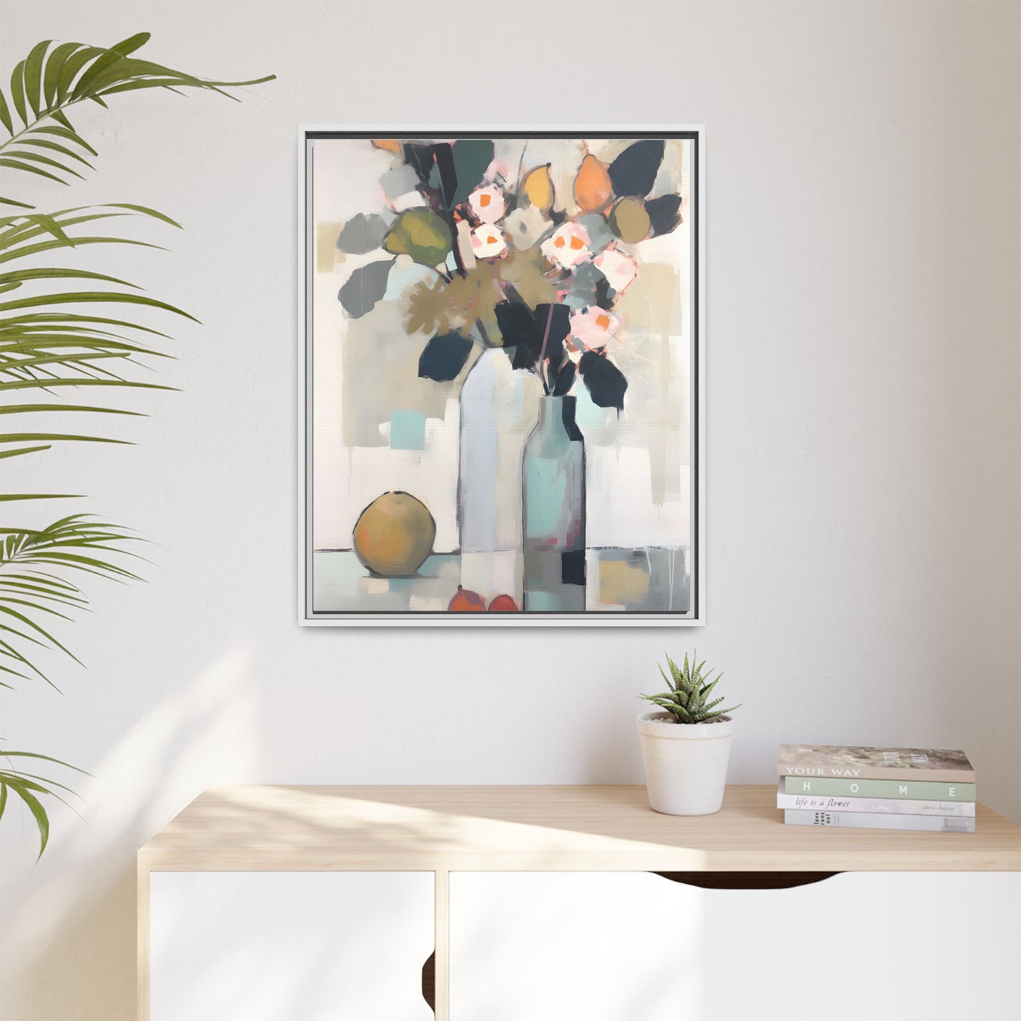 Modern Floral Still Life Wall Art – Framed Canvas with Bold Leaves and Citrus in Vase on display in a living room setting.