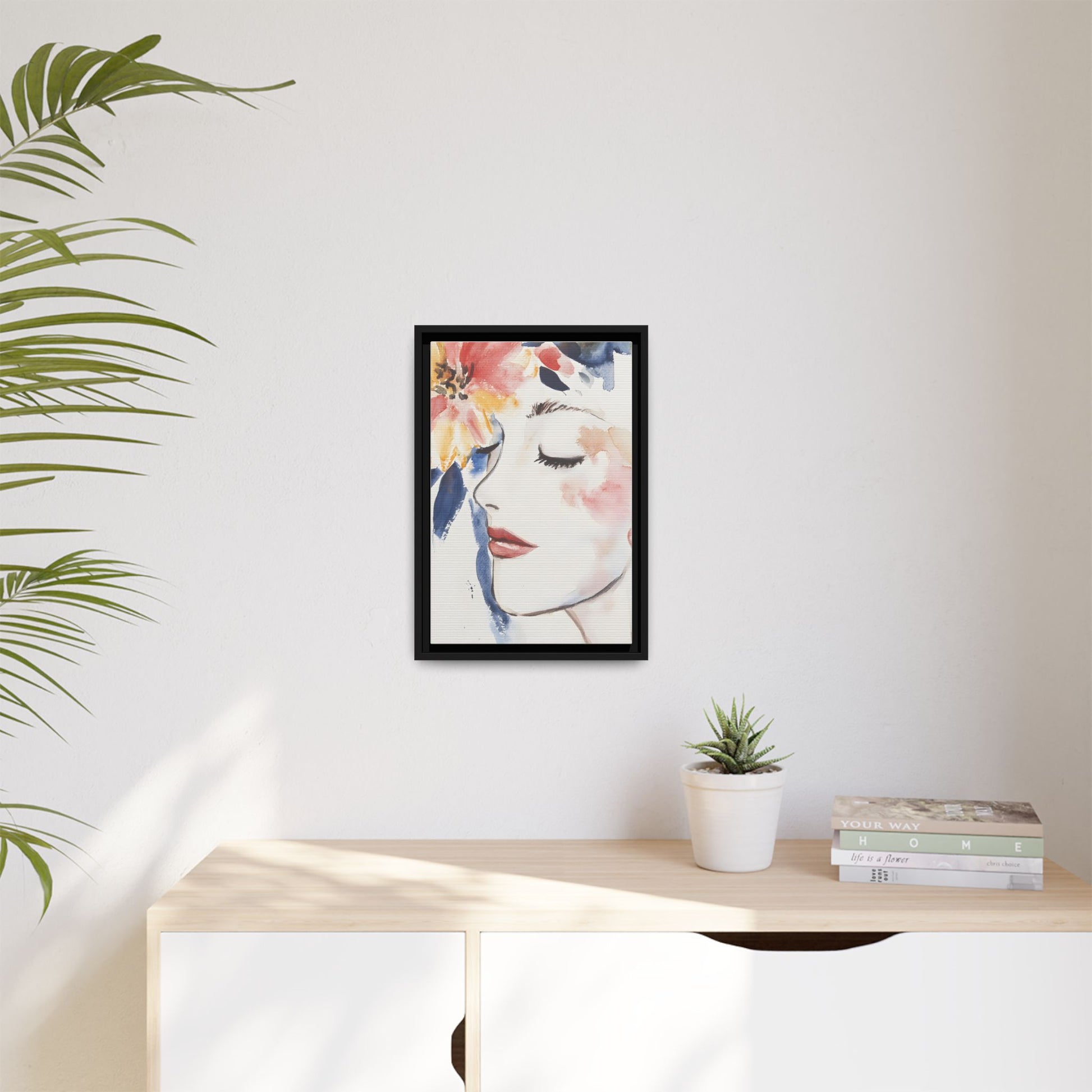 Multi-Color Framed Matte Canvas Art - Floral Face Portrait hanging on a wall in a modern living space with plants.