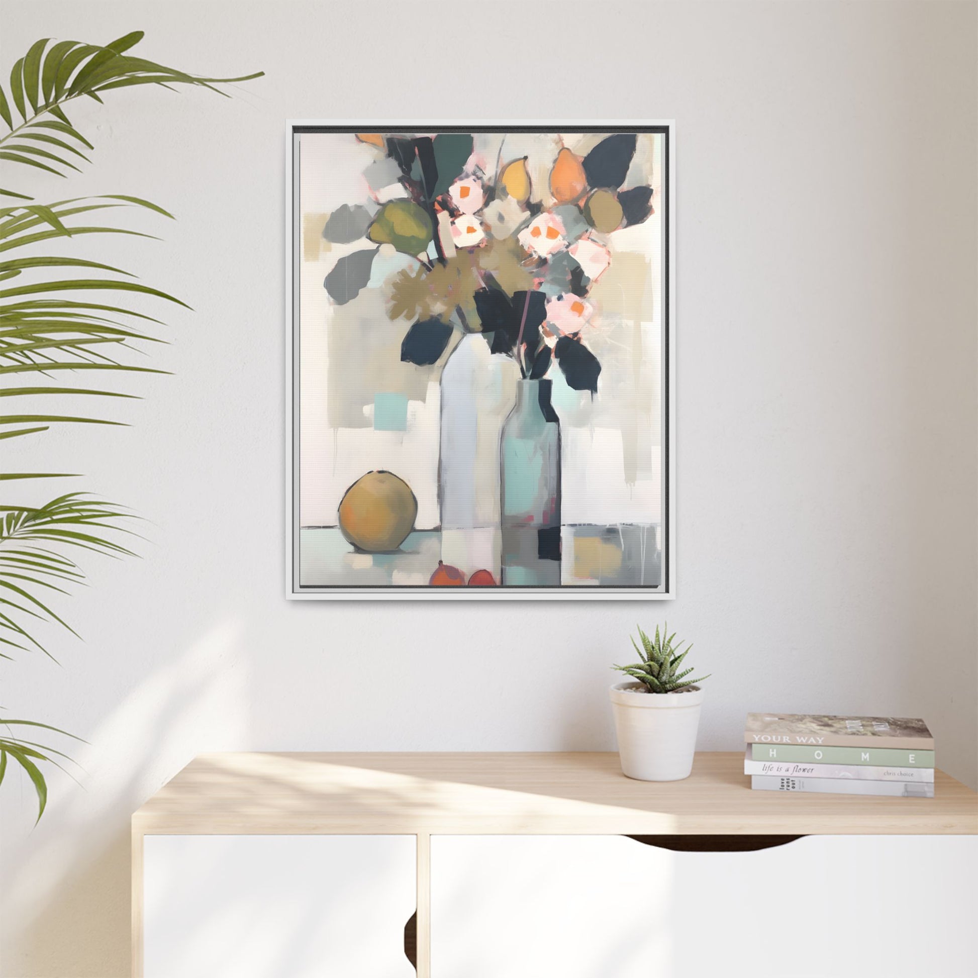 Modern Floral Still Life Wall Art – Framed Canvas with Bold Leaves and Citrus in Vase on display in a living room setting.