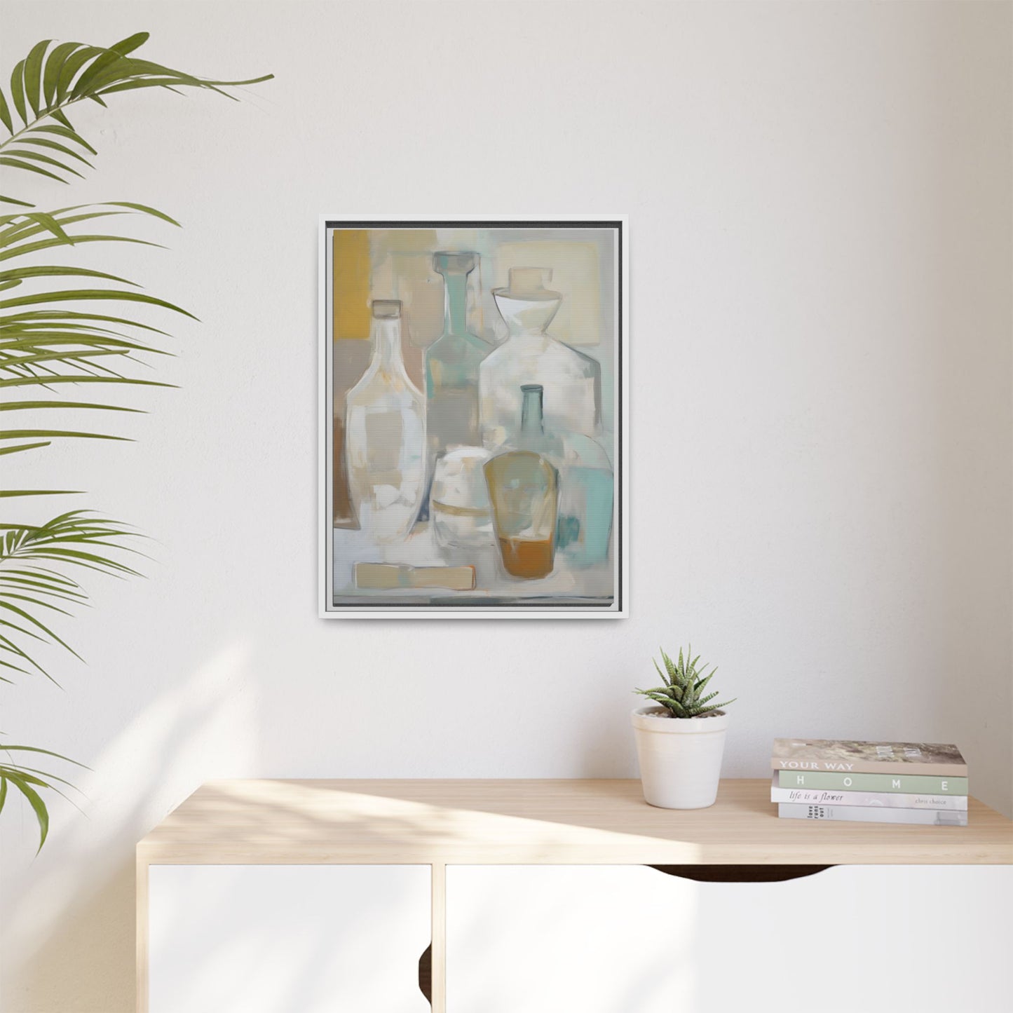 Modern Still Life Wall Art – Neutral Bottles Framed Canvas in Beige, Aqua & Amber hanging on a wall above a cabinet.