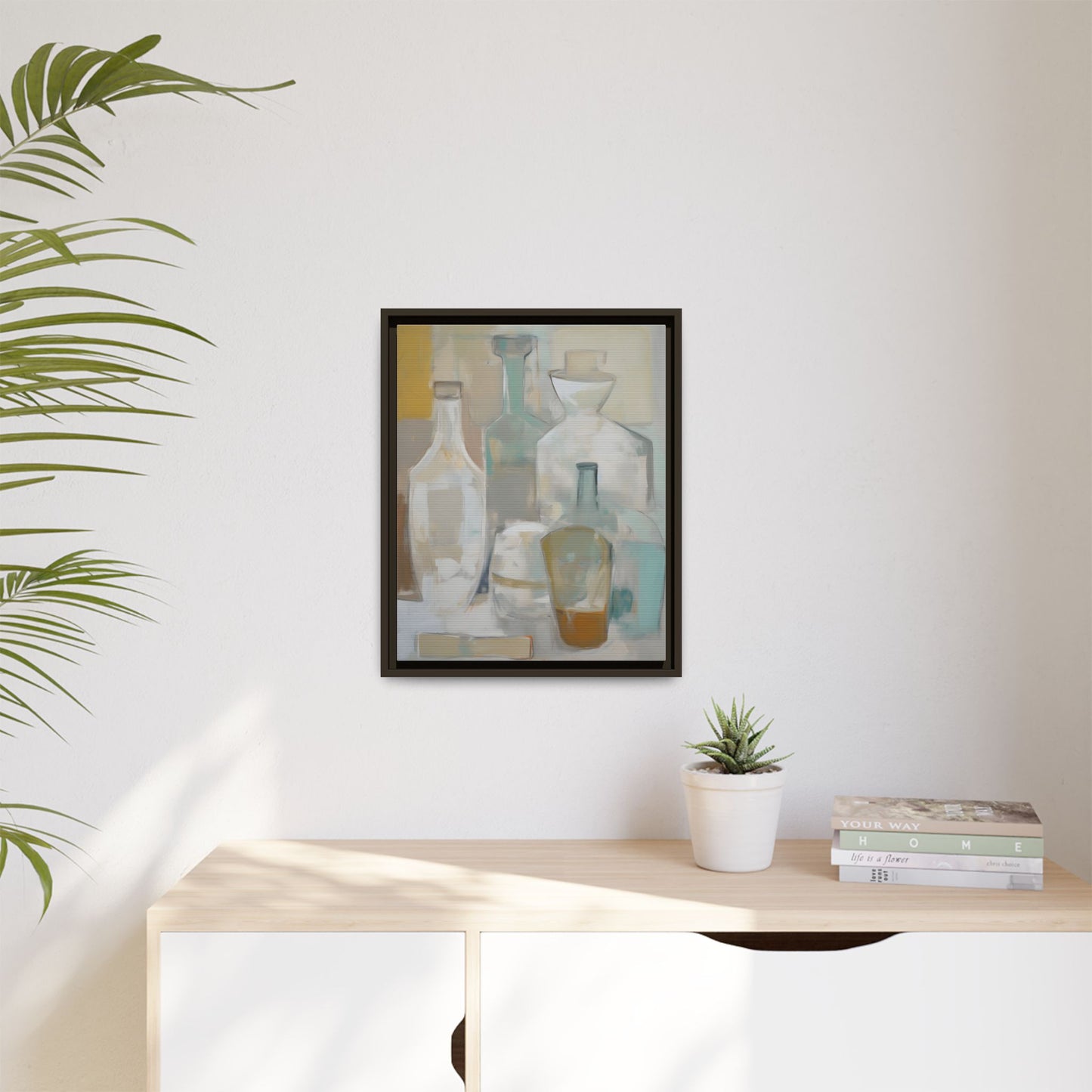 Modern Still Life Wall Art – Neutral Bottles Framed Canvas in Beige, Aqua & Amber hanging in a minimalist interior above a wooden sideboard.