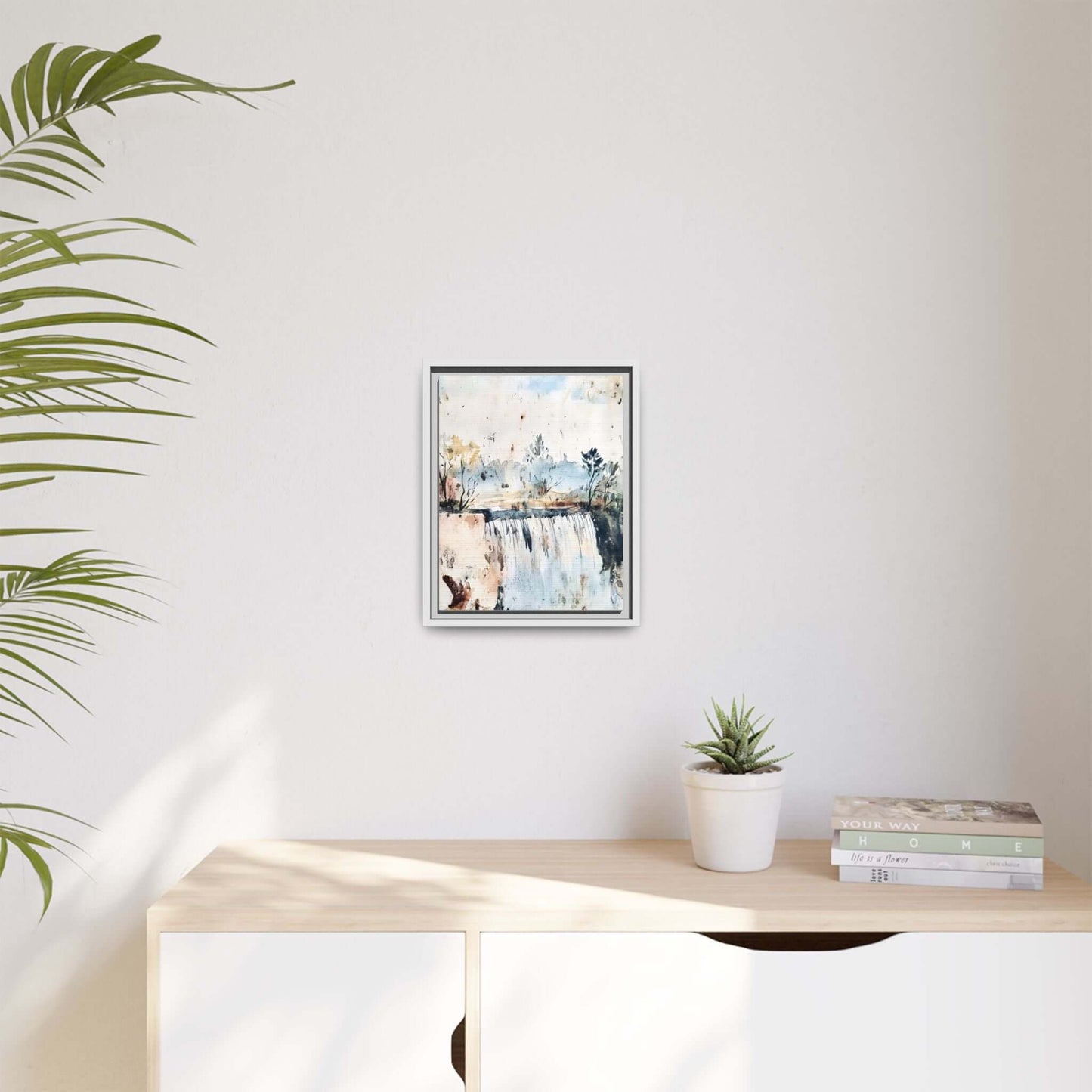 Framed watercolor wall art featuring a serene landscape decor, displayed in a modern room setting with a plant and books on a shelf.