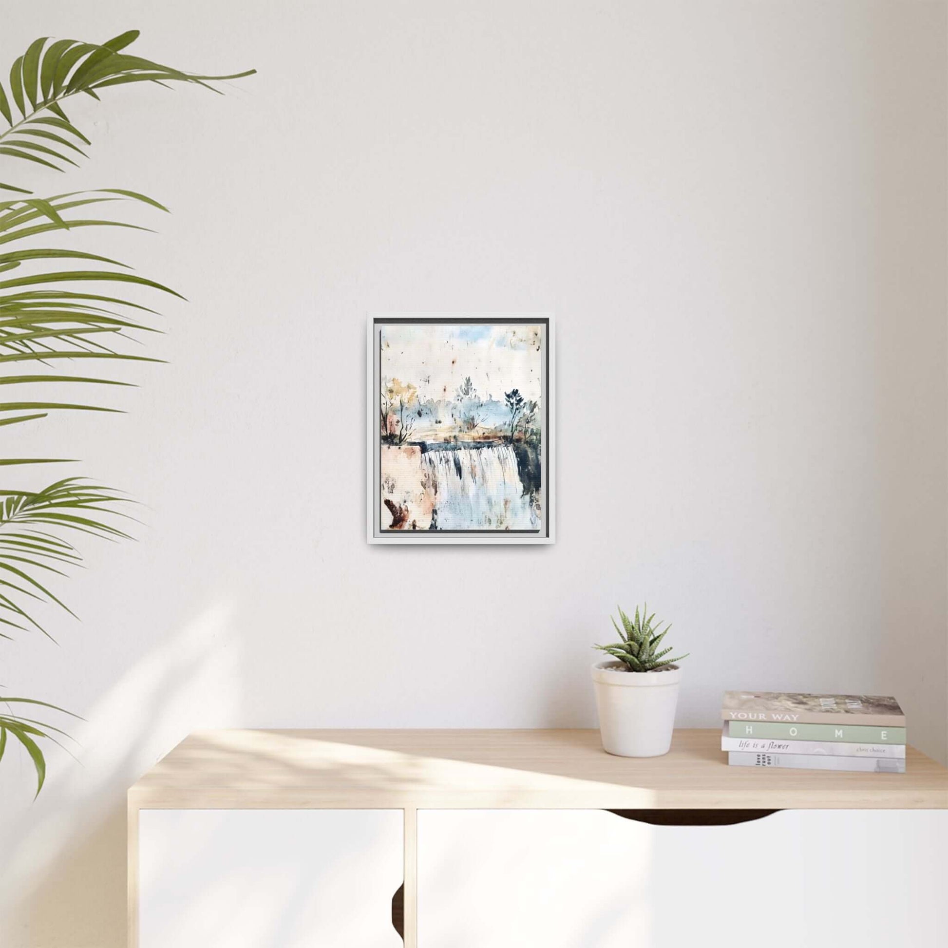 Framed watercolor wall art featuring a serene landscape decor, displayed in a modern room setting with a plant and books on a shelf.