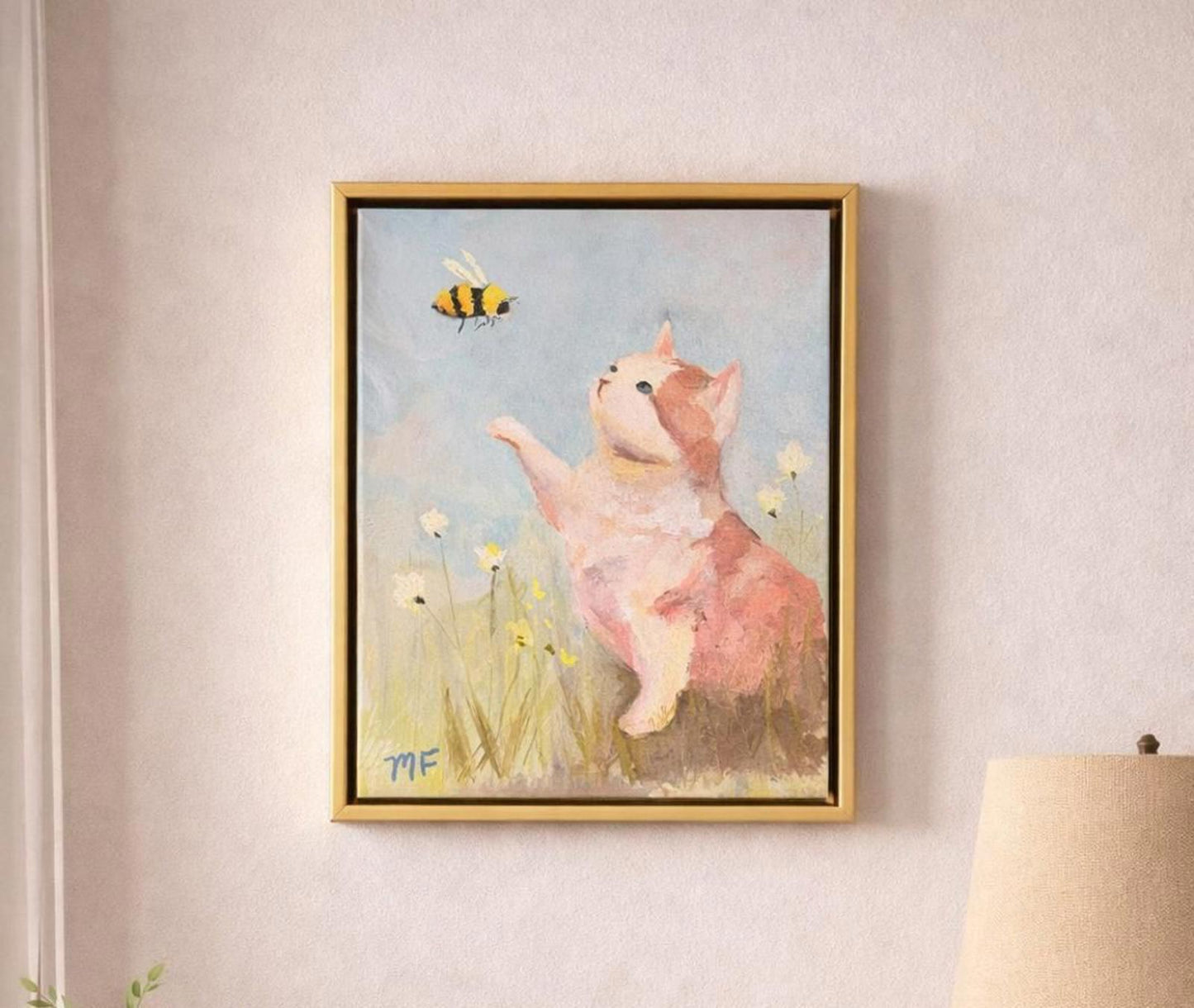 Framed artwork of a cat and butterfly on a wall