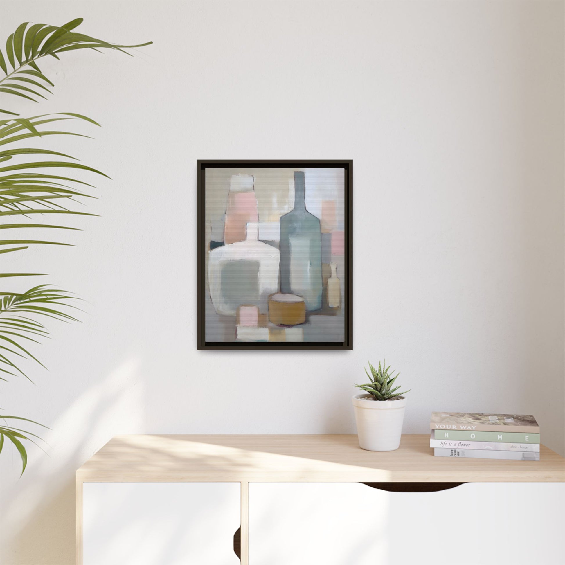 Modern Abstract Bottle Still Life Wall Art – Framed Canvas in Soft Pink, Blue, and Beige displayed on a wall above a shelf.