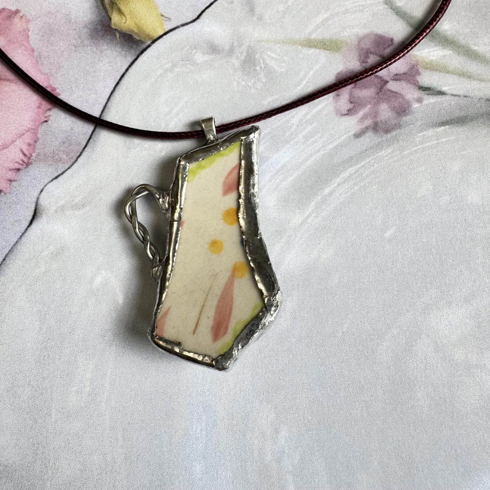 Broken China Teapot Shape Handmade Floral Pendant with pastel floral design on cream background, silver-tone framing, elegant accessory.