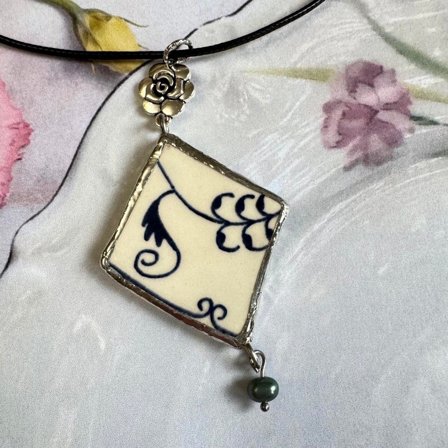 Handmade Broken China Pendant Necklace – Blue Floral Scroll, Rose Charm with dangling freshwater pearl on black cord.
