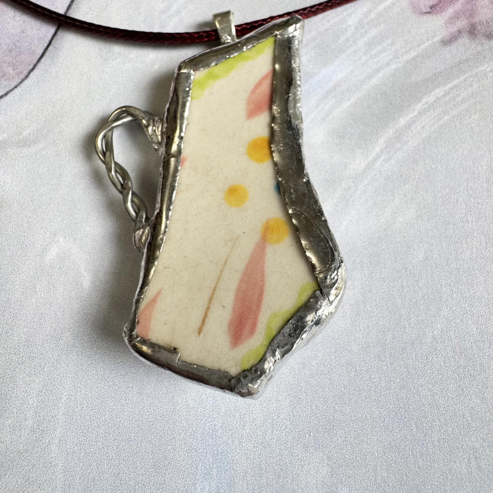 Broken China Teapot Shape Handmade Floral Pendant with pastel floral design on cream background framed in silver-tone metal.