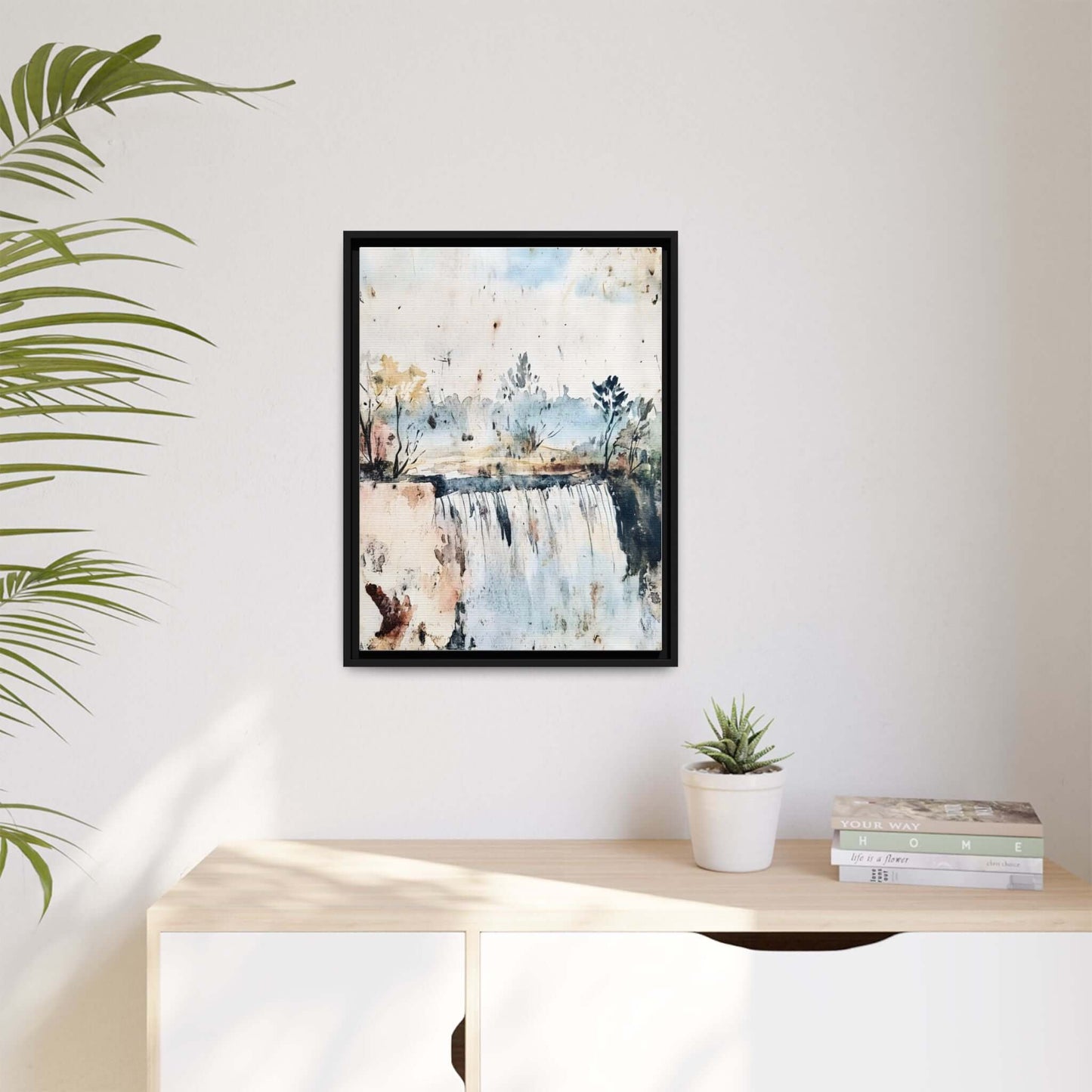 Framed watercolor wall art depicting a serene landscape, elegantly displayed on a minimalist shelf with potted plant and books.