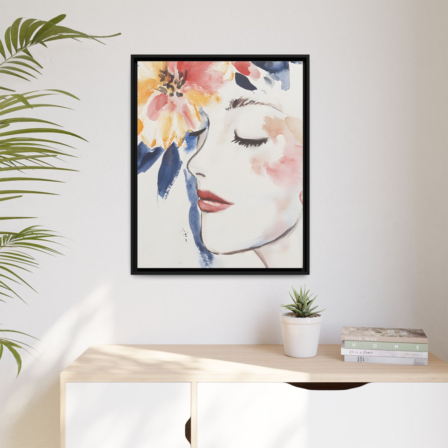 Multi-Color Framed Matte Canvas Art - Floral Face Portrait hanging on a wall above a shelf with plants and books.
