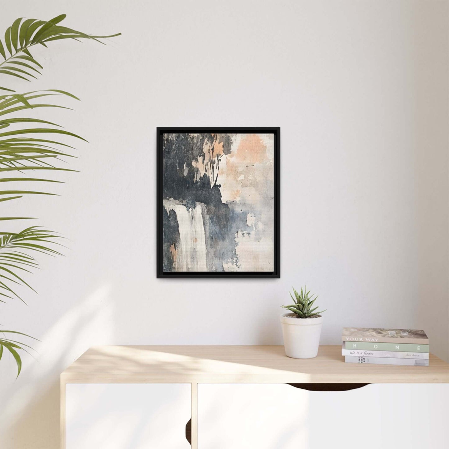 Framed waterfall art print in black frame on light-colored wall, matte canvas home decor for modern interior design.