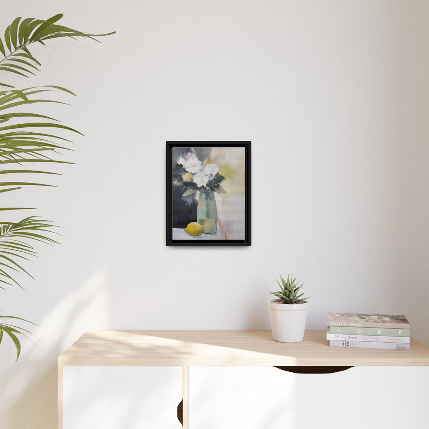 Modern Floral Still Life Wall Art – Framed Canvas with White Flowers and Lemon in Soft Green Vase on a white wall.