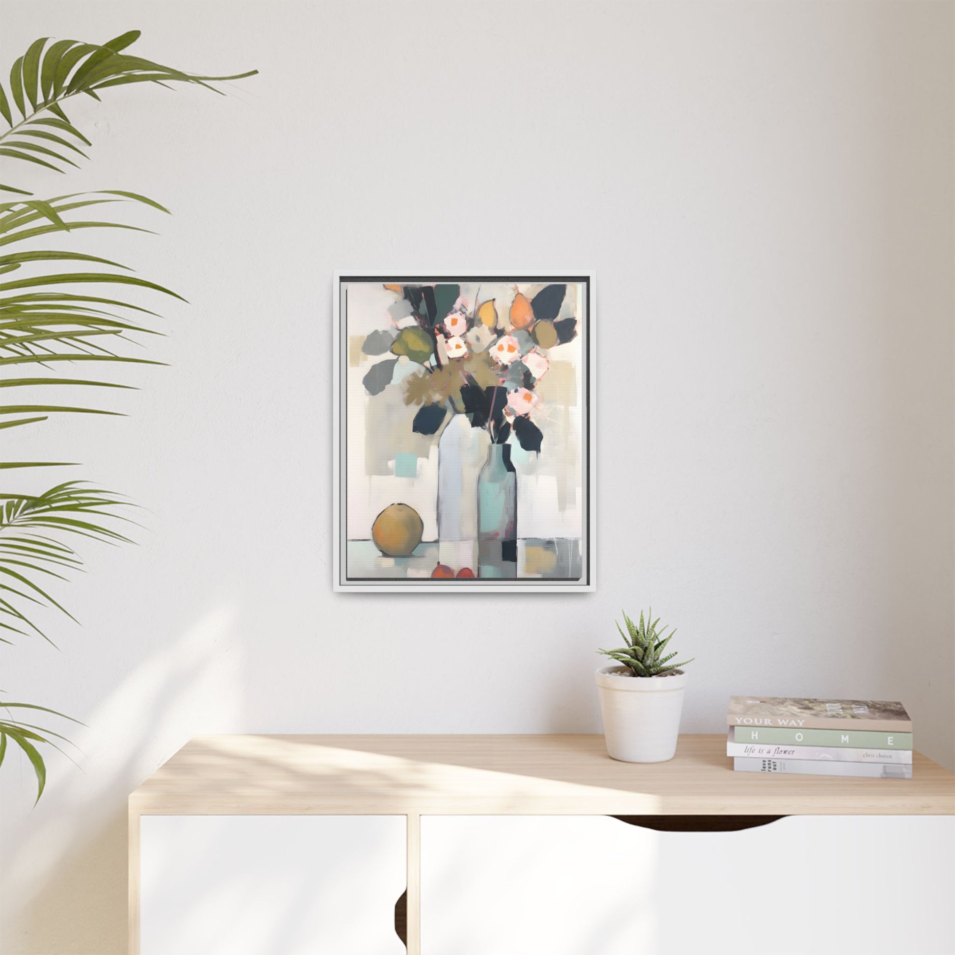 Modern Floral Still Life Wall Art – Framed Canvas with Bold Leaves and Citrus in Vase displayed on white wall above wooden shelf.