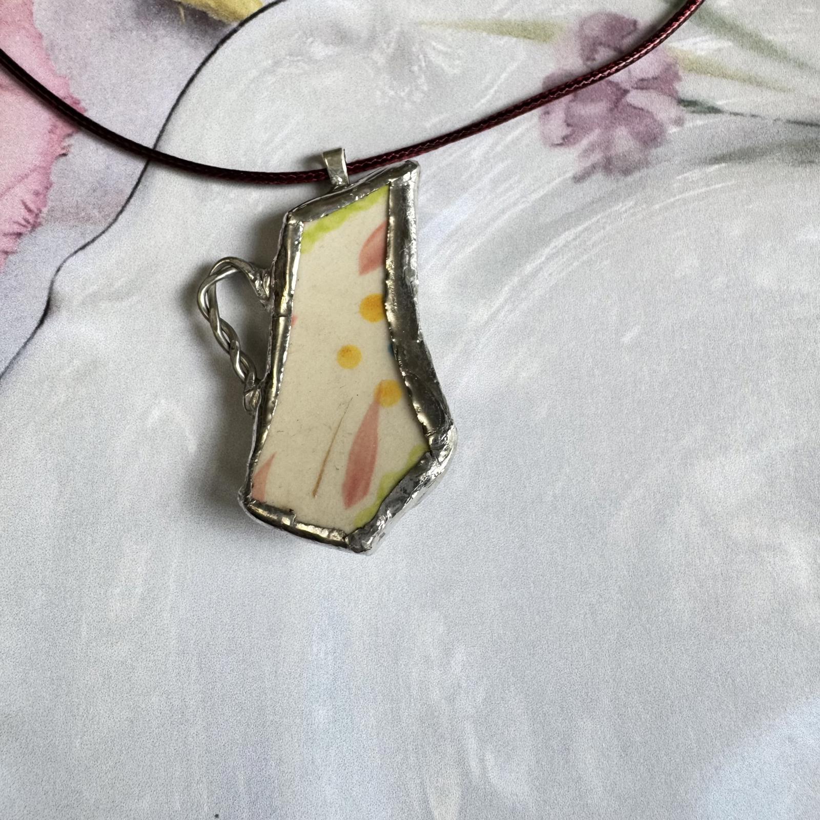 Broken China Teapot Shape Handmade Floral Pendant with silver-tone frame on floral background