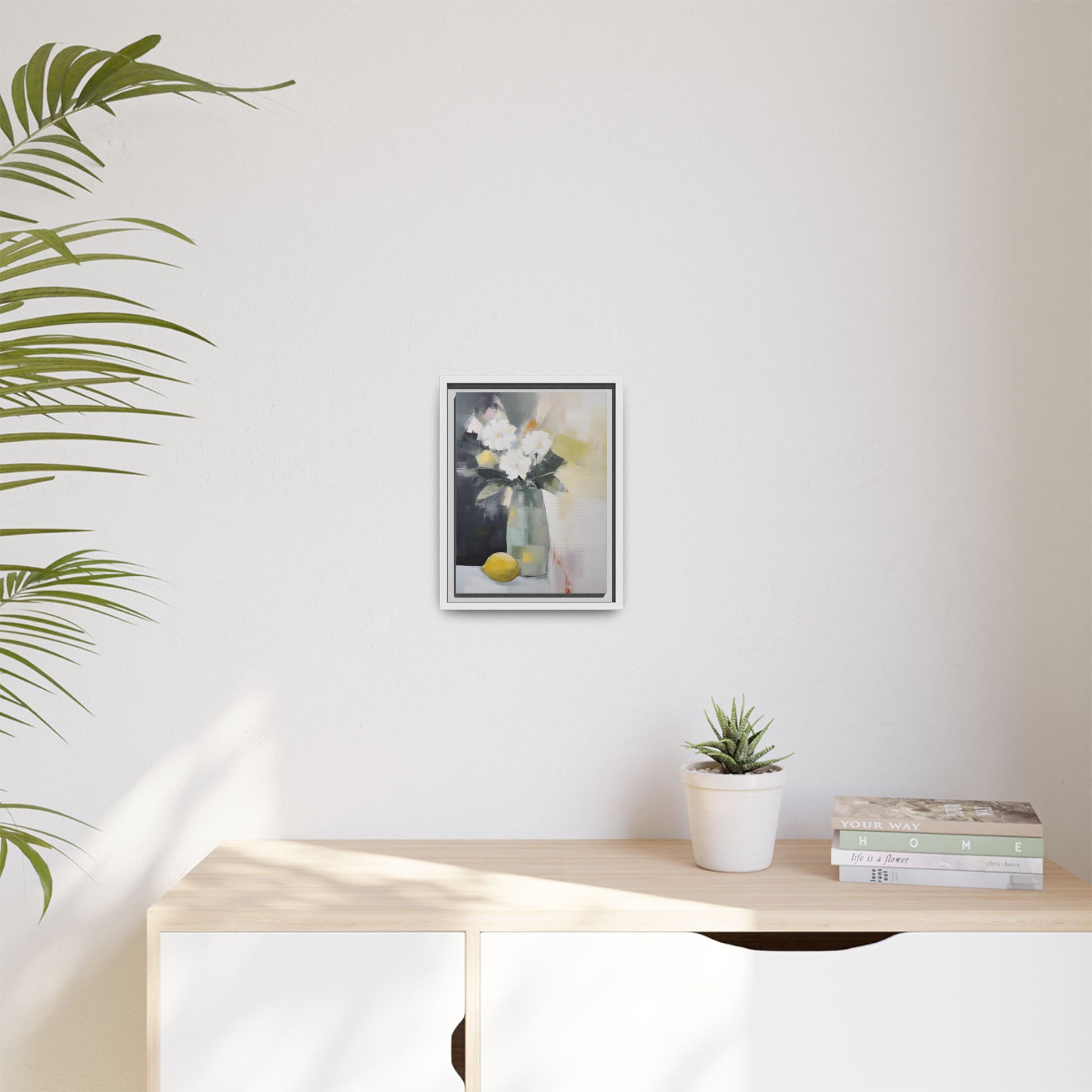 Modern Floral Still Life Wall Art – Framed Canvas with White Flowers and Lemon in Soft Green Vase on minimalist interior wall.