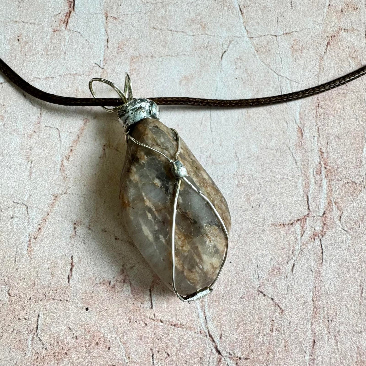 Handcrafted Natural Smokey Quarts Stone Pendant Necklace Boho with silver tone wire wrap on textured background.