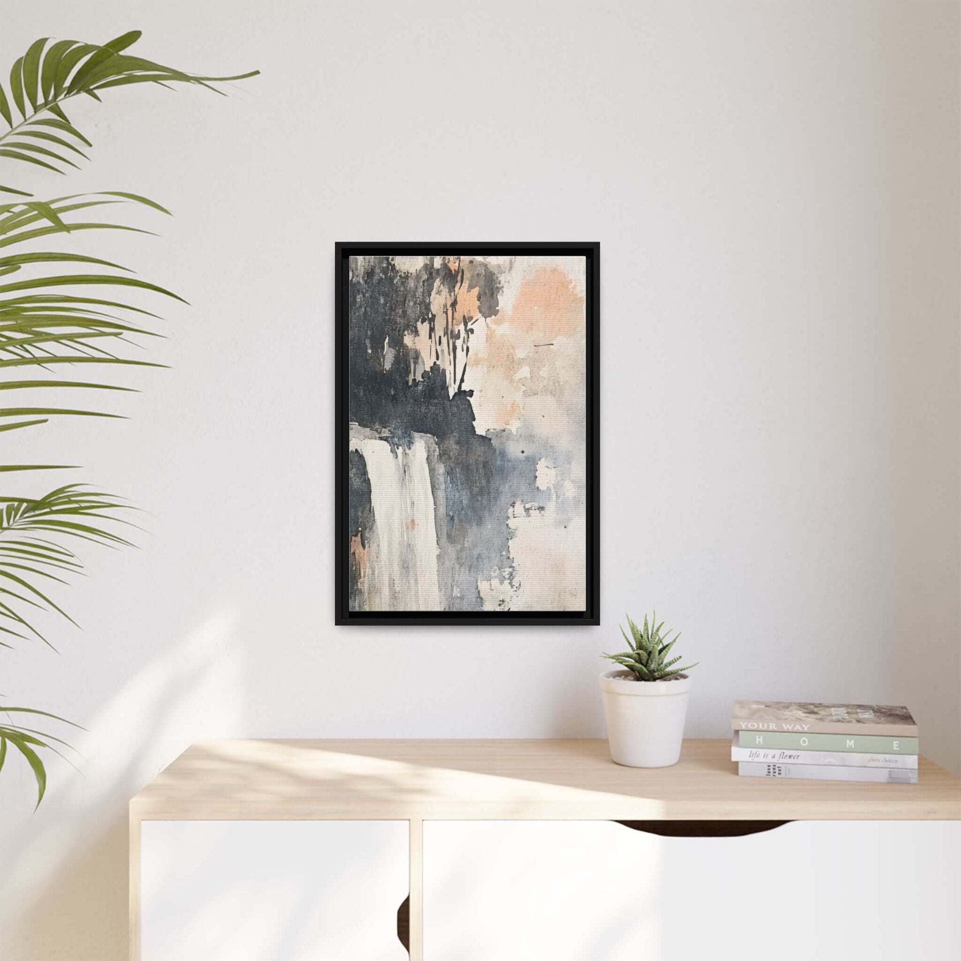 Framed watercolor waterfall art print on matte canvas, styled in modern home decor setting with plants and books.