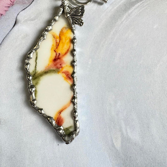 Handcrafted VTG Broken China Floral Pendant Necklace with Long Silver Tone Chain featuring yellow, orange, and green floral design.