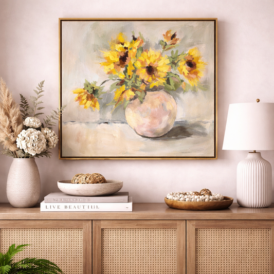Framed painting of sunflowers on a wall above a wooden console table with decorative items.
